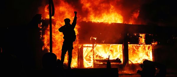 A protester gestures as buildings burn during continued demonstrations against the death in Minneapolis police custody of African-American man George Floyd, in Minneapolis, Minnesota, U.S., May 30, 2020 A protester gestures as buildings burn during continued demonstrations against the death in Minneapolis police custody of African-American man George Floyd, in Minneapolis, Minnesota, U.S., May 30, 2020 - Sputnik International