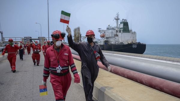 A worker of the Venezuelan state oil company PDVSA waves an Iranian flag as the Iranian-flagged oil tanker Fortune docks at the El Palito refinery in Puerto Cabello, in the northern state of Carabobo, Venezuela, on May 25, 2020 - Sputnik International