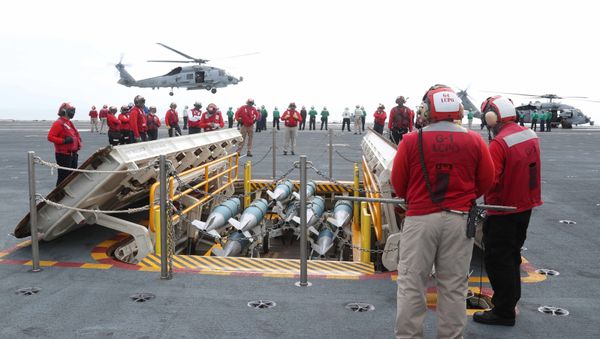 Aviation Ordnancemen assigned to USS Gerald R. Ford's (CVN 78) weapons department bring inert training bombs up to the flight deck during flight operations May 30, 2020. - Sputnik International