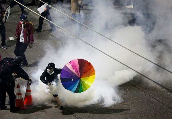 A protester with a rainbow umbrella picks up a gas canister as law enforcement deploys chemical agents and blast balls during a protest against racial inequality in the aftermath of the death in Minneapolis police custody of George Floyd, near the Seattle Police department's East Precinct in Seattle, Washington, U.S. June 8, 2020. A protester with a rainbow umbrella picks up a gas canister as law enforcement deploys chemical agents and blast balls during a protest against racial inequality in the aftermath of the death in Minneapolis police custody of George Floyd, near the Seattle Police department's East Precinct in Seattle, Washington, U.S. June 8, 2020. - Sputnik International