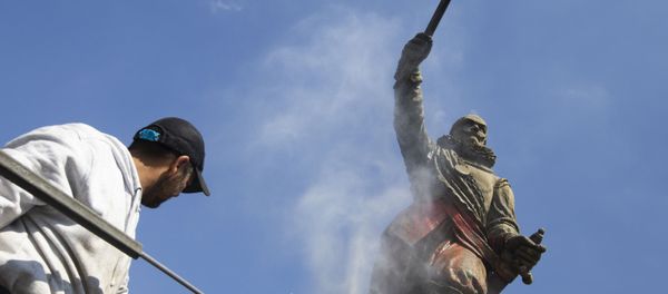 A municipal worker used a high pressure water cleaner to remove the paint from the statue of Piet Hein in Rotterdam, Netherlands, Friday, June 12, 2020. Dutch activists have spray painted the words killer and thief and daubed red paint on a statue of a man regarded by many as a naval hero from the 17th-century Golden Era of Dutch trade and colonial expansion. (AP Photo/Peter Dejong) - Sputnik International