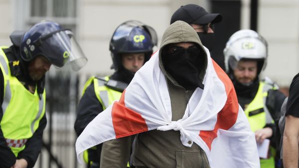 A masked protester walks as British police officers in riot gear escort him and others away in central London, as groups gather to counter-protest against a Black Lives Matter demonstration, Saturday, June 13, 2020. - Sputnik International