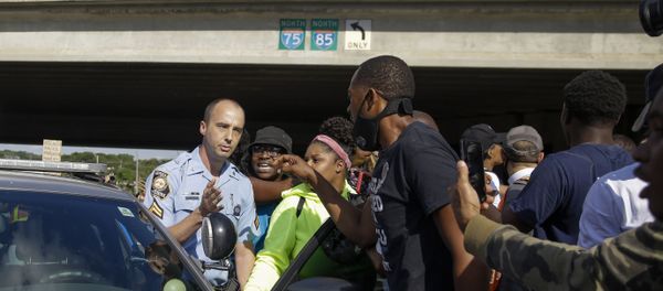 Protesters block a Georgia State Patrol official from leaving, Saturday, June 13, 2020, near the Wendy's restaurant where Rayshard Brooks was shot and killed by police Friday evening following a struggle in the restaurant's drive-thru line in Atlanta. - Sputnik International