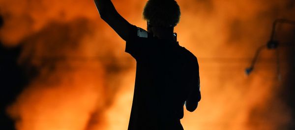 A protester watches as a Wendy’s burns following a rally against racial inequality and the police shooting death of Rayshard Brooks, in Atlanta, Georgia, U.S. June 13, 2020. - Sputnik International