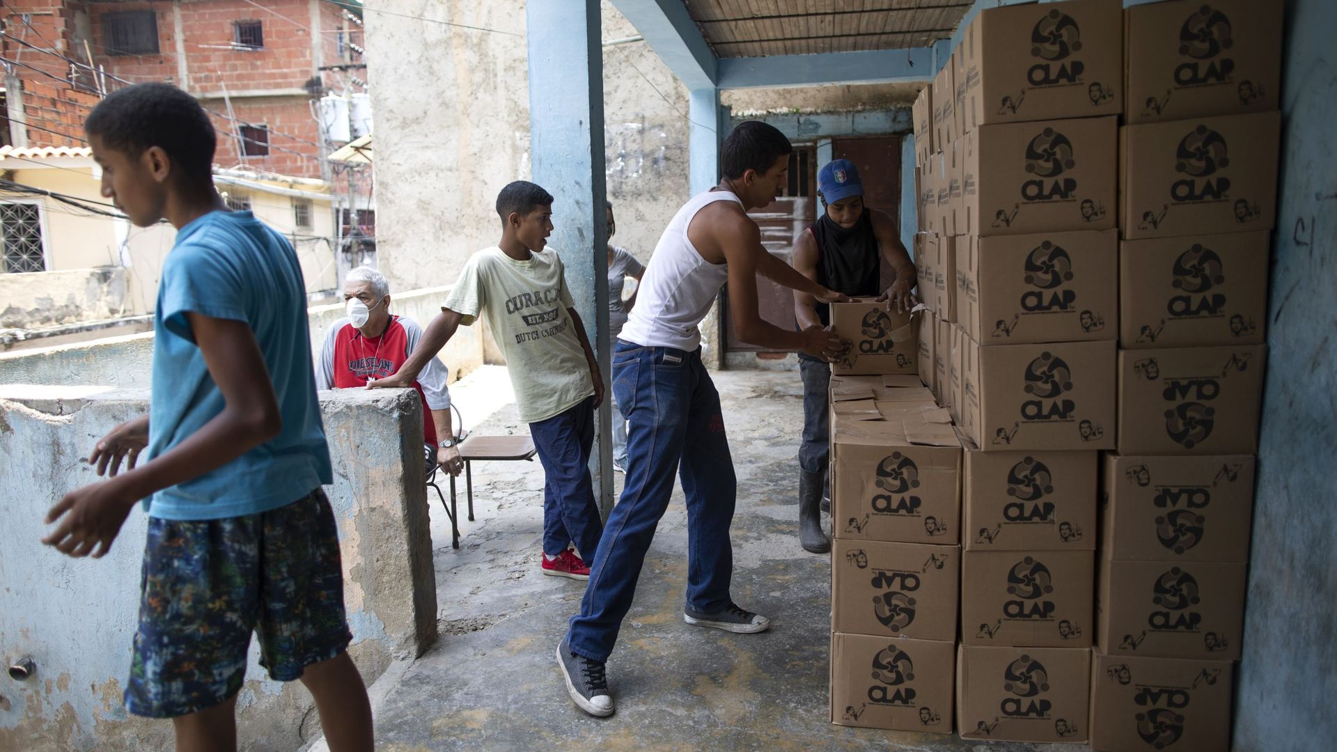 Residents help to unload and stack boxes of basic food staples, such as pasta, sugar and flour, provided by a government food assistance program, in Caracas’ slum of Petare, Venezuela, Thursday, April 30, 2020. Residents help to unload and stack boxes of basic food staples, such as pasta, sugar and flour, provided by a government food assistance program, in Caracas’ slum of Petare, Venezuela, Thursday, April 30, 2020. - Sputnik International, 1920, 20.04.2021