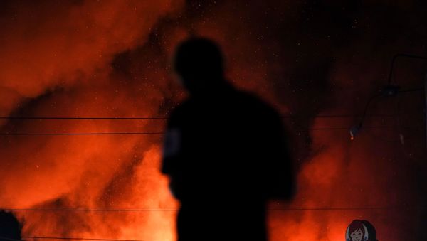 A protester watches as a Wendy’s burns following a rally against racial inequality and the police shooting death of Rayshard Brooks, in Atlanta, Georgia, U.S. June 13, 2020. - Sputnik International