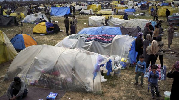 Migrants stand by tends in a camp set up near the Turkish-Greek border in Pazarkule, Edirne region, Turkey, Tuesday, March 10, 2020 - Sputnik International