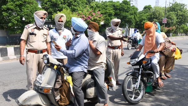 Police personnel check commuters after strict lockdown norms for weekends and public holidays were imposed as a preventive measure against the COVID-19 coronavirus, in Amritsar on June 14, 2020 - Sputnik International