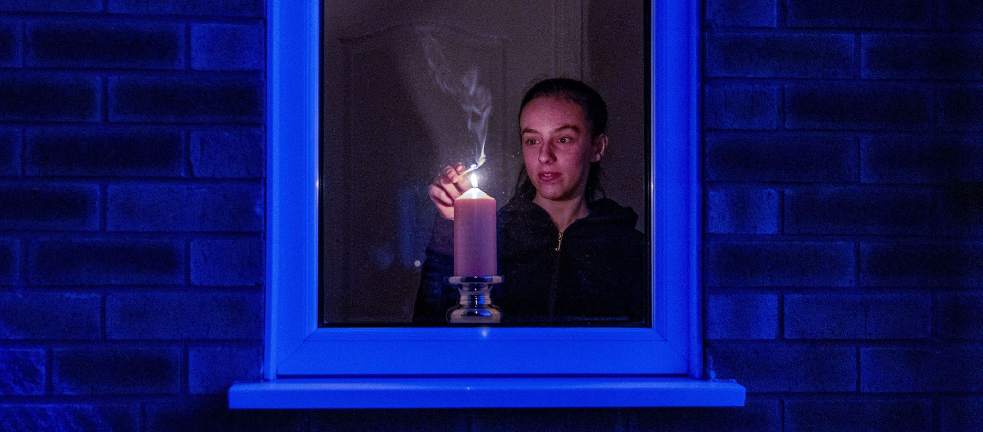 Woman lights a candle in the window of a home in Liverpool, England, after the Queen stressed the importance of maintaining the coronavirus lockdown during the Easter Bank Holiday weekend as she delivered what is believed to be her first Easter address, Saturday, April 11, 2020 Woman lights a candle in the window of a home in Liverpool, England, after the Queen stressed the importance of maintaining the coronavirus lockdown during the Easter Bank Holiday weekend as she delivered what is believed to be her first Easter address, Saturday, April 11, 2020 - Sputnik International, 1920, 15.06.2020