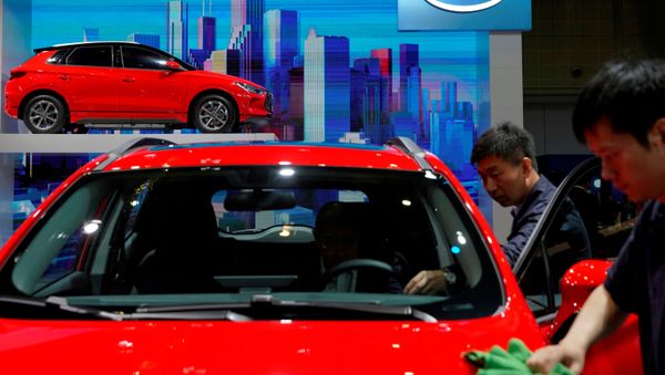 Men clean a BYD electric vehicle (EV) e2 displayed during the media day for Shanghai auto show Men clean a BYD electric vehicle (EV) e2 displayed during the media day for Shanghai auto show - Sputnik International
