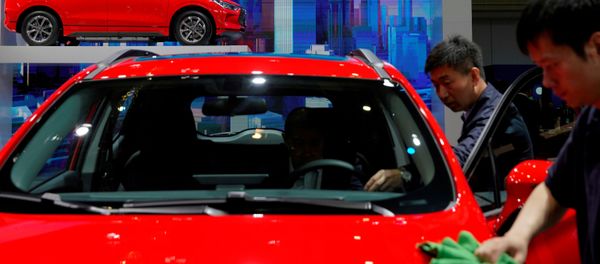 Men clean a BYD electric vehicle (EV) e2 displayed during the media day for Shanghai auto show - Sputnik International