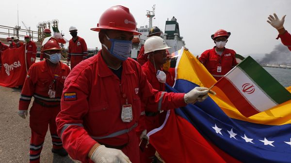 A Venezuelan oil worker holding a small Iranian flag attends a ceremony for the arrival of Iranian oil tanker Fortune at the El Palito refinery near Puerto Cabello, Venezuela, Monday, May 25, 2020 - Sputnik International