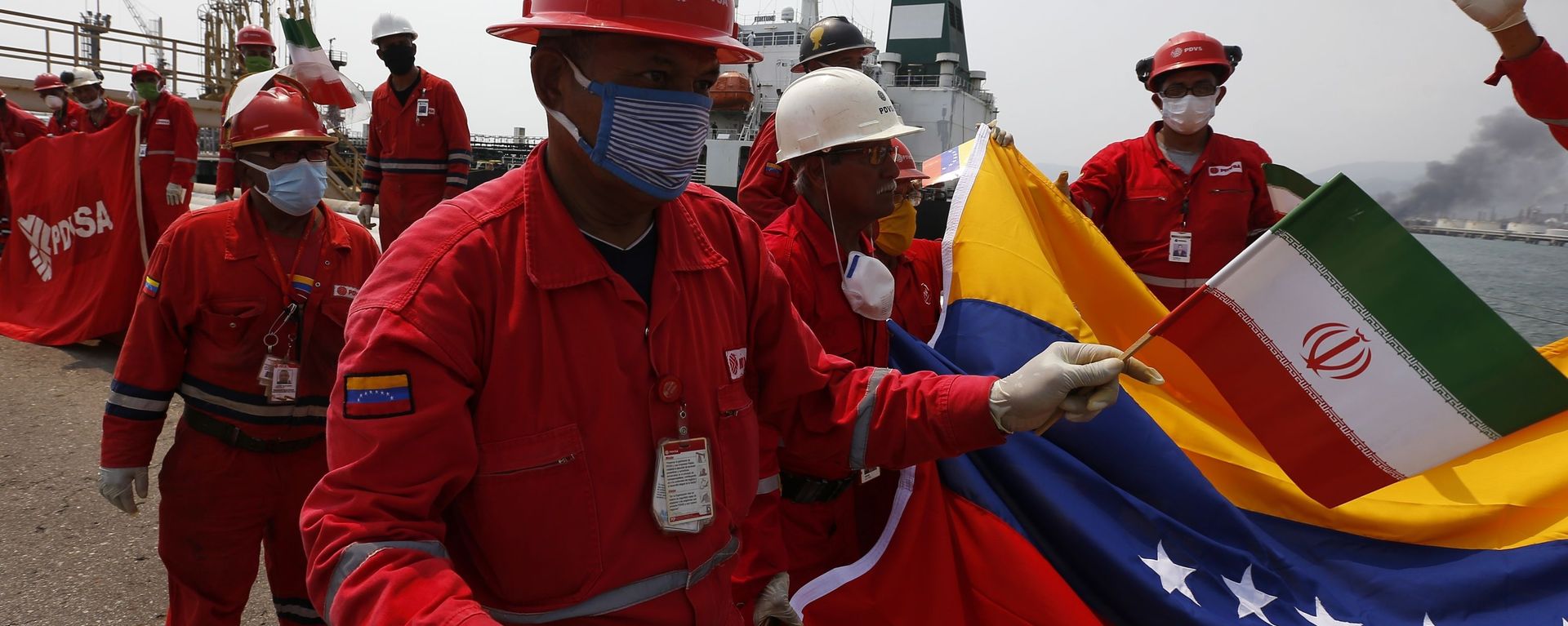 A Venezuelan oil worker holding a small Iranian flag attends a ceremony for the arrival of Iranian oil tanker Fortune at the El Palito refinery near Puerto Cabello, Venezuela, 25 May 2020 A Venezuelan oil worker holding a small Iranian flag attends a ceremony for the arrival of Iranian oil tanker Fortune at the El Palito refinery near Puerto Cabello, Venezuela, 25 May 2020 - Sputnik International, 1920, 24.09.2020