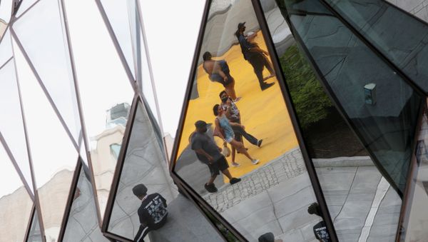 Pedestrians are seen reflected in a building mirror along Black Lives Matter Plaza near the White House in Washington, D.C. June 16, 2020.  - Sputnik International