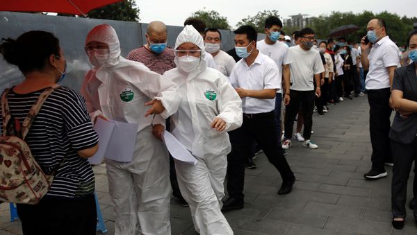 Medical workers in protective suits attend to people lining up outside a site for nucleic acid tests, following new cases of coronavirus disease (COVID-19) infections in Beijing, China June 17, 2020. REUTERS/Tingshu Wang Medical workers in protective suits attend to people lining up outside a site for nucleic acid tests, following new cases of coronavirus disease (COVID-19) infections in Beijing, China June 17, 2020. REUTERS/Tingshu Wang - Sputnik International