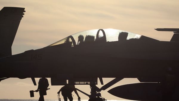 Flight deck personnel work beneath an F/A-18F Super Hornet fighter aircraft, aboard the USS Nimitz (CVN 68) aircraft carrier while at sea, on January 18, 2020 off the coast of Baja California, Mexico. The USS Nimitz is currently conducting routine operations and training at sea. The nuclear-powered aircraft carrier holds a flight deck area of 4.5 acres and can hold 65 aircraft along with nearly 5,000 total personnel. It is the oldest U.S. Navy carrier in active service and was commissioned on May 3, 1975. - Sputnik International