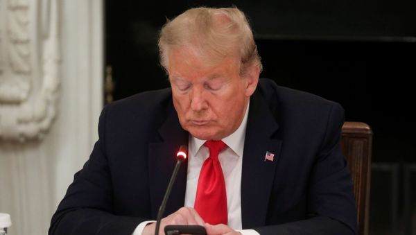 U.S. President Donald Trump uses a mobile phone during a roundtable discussion on the reopening of small businesses in the State Dining Room at the White House in Washington, U.S., June 18, 2020 - Sputnik International