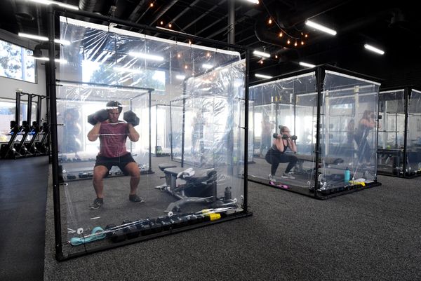 People exercise at Inspire South Bay Fitness behind plastic sheets in their workout pods while observing social distancing on 15 June 2020 in Redondo Beach, California, as the gym reopens under California's coronavirus Phase 3 reopening guidelines. - Sputnik International