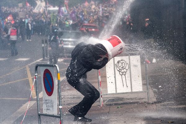 A protester protects himself with a bucket while being hit by a police water cannon in front of a regional prefecture during a demonstration in Nantes on 16 June 2020 as part of a nationwide day of protests to demand better working conditions for health workers. - Sputnik International