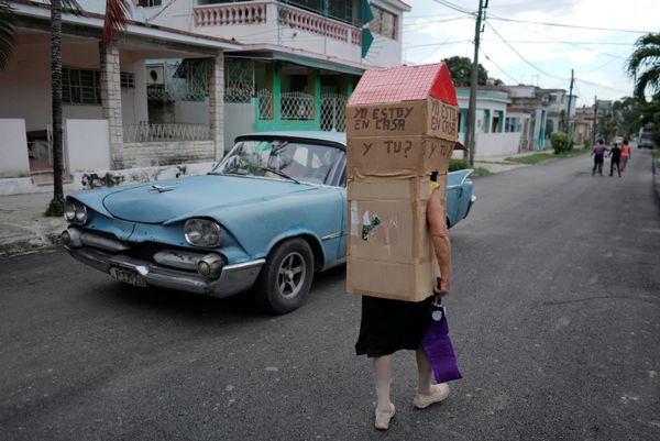 Retired nurse Feridia Rojas, 82, walks past a vintage car as she wears cardboard shaped like a house to protect herself from the spread of the coronavirus disease (COVID-19) outbreak in Havana, Cuba, 16 June 2020. The words on the cardboard read: I am at home. And you? - Sputnik International