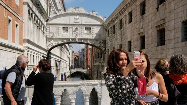 Tourists are seen by the Bridge of Sighs a day before Italy and neighbouring EU countries open up borders for the first time since the coronavirus disease (COVID-19) outbreak hit the country, in Venice, Italy June 14, 2020. - Sputnik International