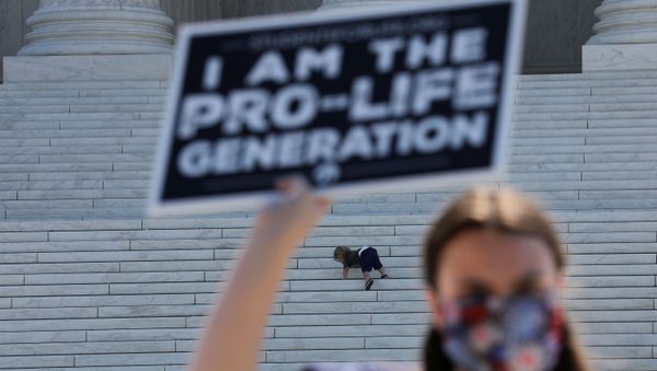 A child plays on the steps of the U.S. Supreme Court building as an anti-abortion activist holds a sign during a demonstration outside the court in Washington, U.S., June 29, 2020 A child plays on the steps of the U.S. Supreme Court building as an anti-abortion activist holds a sign during a demonstration outside the court in Washington, U.S., June 29, 2020 - Sputnik International