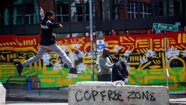 Jamil jumps onto a barricade with graffiti reading Cop free zone as his parents stand nearby at the CHOP area as people continue to occupy space and protest against racial inequality in the aftermath of the death in Minneapolis police custody of George Floyd, in Seattle, Washington, U.S. June 28, 2020. Jamil jumps onto a barricade with graffiti reading Cop free zone as his parents stand nearby at the CHOP area as people continue to occupy space and protest against racial inequality in the aftermath of the death in Minneapolis police custody of George Floyd, in Seattle, Washington, U.S. June 28, 2020. - Sputnik International
