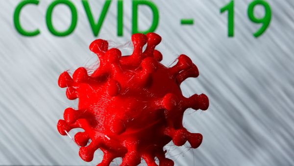 A 3D-printed coronavirus model is seen in front of the words coronavirus disease (Covid-19) on display in this illustration taken March 25, 2020. - Sputnik International
