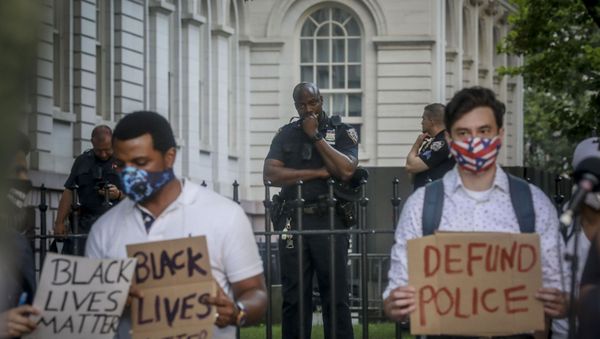 A New York City police officer, among a detail of police guarding City Hall, watches as organizers with City Workers4Justice–an activist organization for city employees–prepare to lead a rally and march calling on Mayor Bill de Blasio to defund the police department, Thursday June 25, 2020, in New York. A New York City police officer, among a detail of police guarding City Hall, watches as organizers with City Workers4Justice–an activist organization for city employees–prepare to lead a rally and march calling on Mayor Bill de Blasio to defund the police department, Thursday June 25, 2020, in New York. - Sputnik International