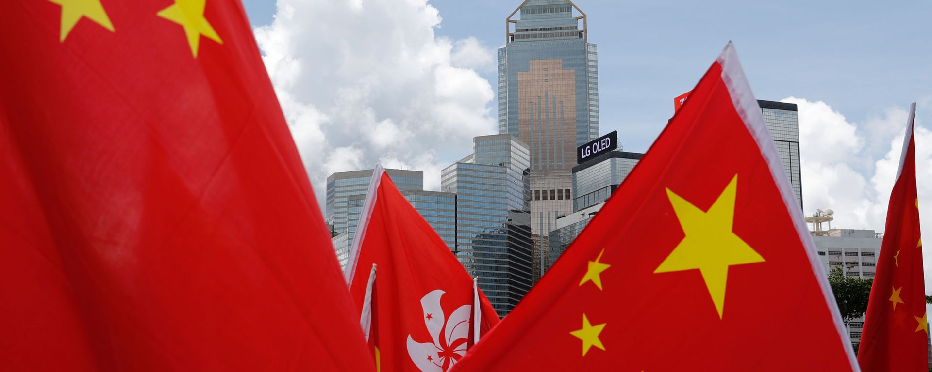 Buildings are seen above Hong Kong and Chinese flags, as pro-China supporters celebration after China's parliament passes national security law for Hong Kong, in Hong Kong, China June 30, 2020.  - Sputnik International, 1920, 03.07.2020