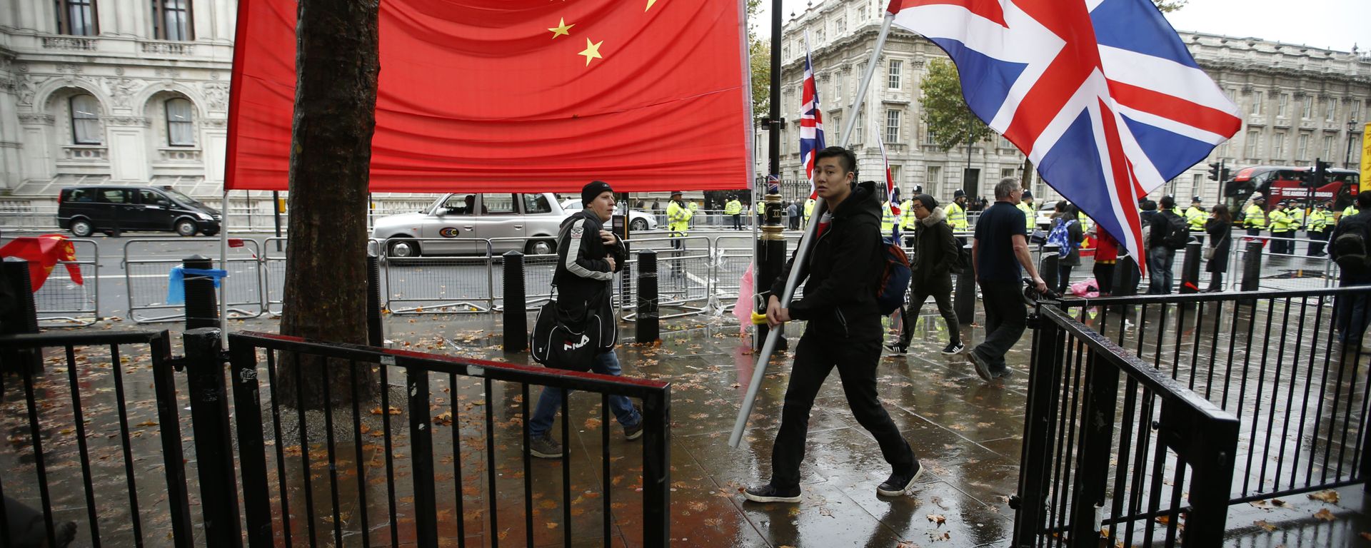 A supporter of Chinese President Xi Jinping carries a large British flag past the national flag of China outside Downing Street where he is meeting the British Prime Minister David Cameron in London, Wednesday, Oct. 21, 2015 A supporter of Chinese President Xi Jinping carries a large British flag past the national flag of China outside Downing Street where he is meeting the British Prime Minister David Cameron in London, Wednesday, Oct. 21, 2015 - Sputnik International, 1920, 23.02.2024
