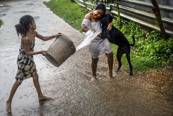 A girl throws water to a friend as they play under in the rain in Havana, Cuba, Wednesday, July 1, 2020 A girl throws water to a friend as they play under in the rain in Havana, Cuba, Wednesday, July 1, 2020 - Sputnik International