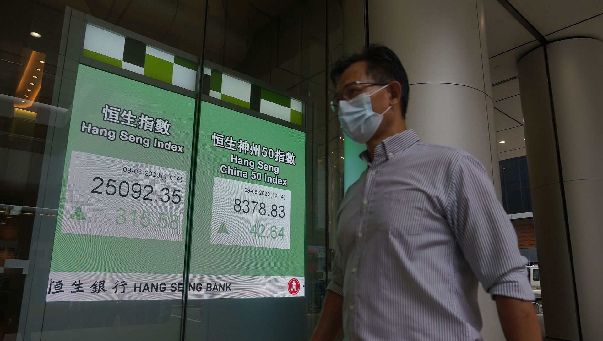 A man wearing a face mask walks past a bank electronic board showing the Hong Kong share index at Hong Kong Stock Exchange Tuesday, June 9, 2020. A man wearing a face mask walks past a bank electronic board showing the Hong Kong share index at Hong Kong Stock Exchange Tuesday, June 9, 2020. - Sputnik International, 1920, 09.04.2021