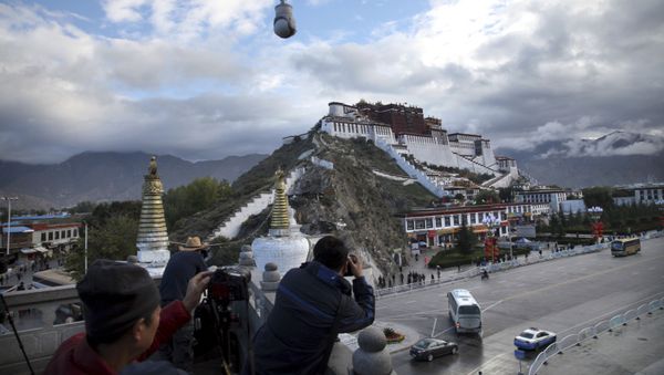 FILE - In this Sept. 19, 2015, file photo, tourists take photos of the Potala Palace beneath a security camera in Lhasa, capital of the Tibet Autonomous Region of China - Sputnik International
