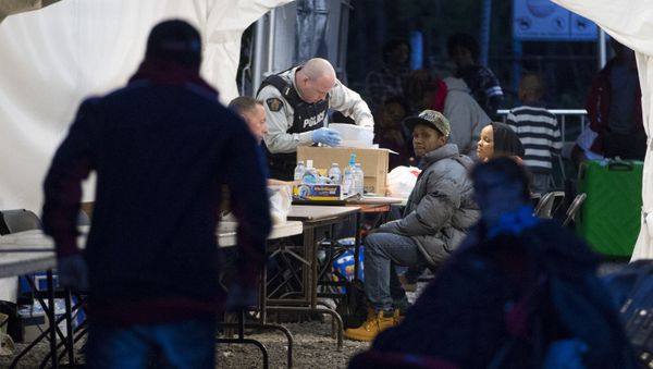 Refugees who crossed the Canada/US border illegally near Hemmingford, Quebec are processed in a tent after being arrested by the Royal Canadian Mounted Police - Sputnik International