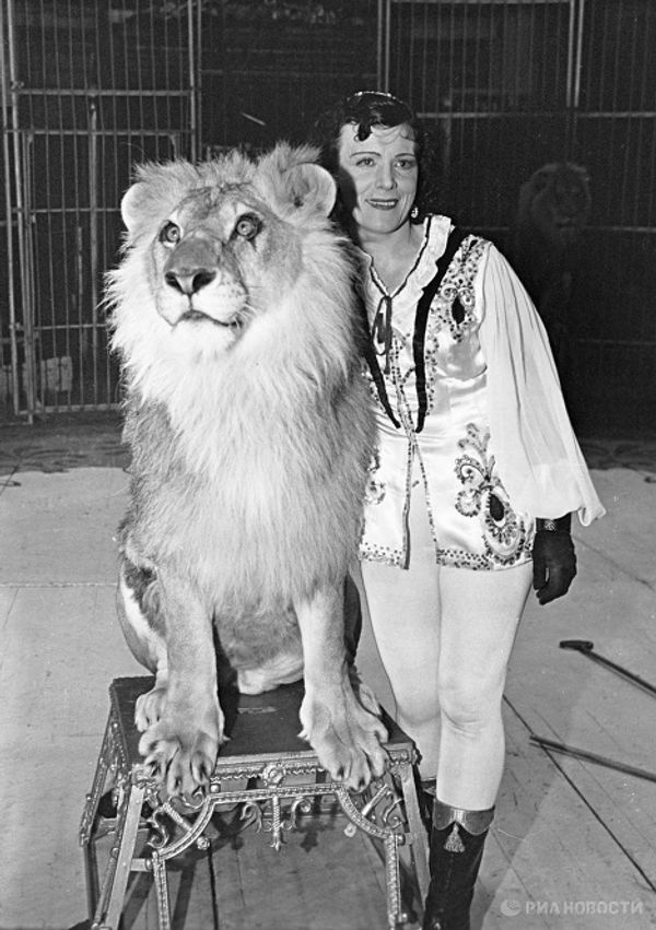 Animal tamer Irina Bugrimova with lions at her feet Animal tamer Irina Bugrimova with lions at her feet - Sputnik International