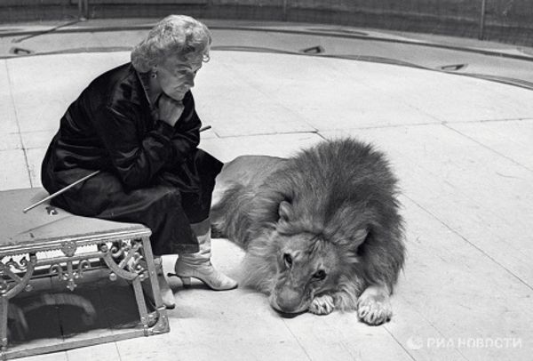 Animal tamer Irina Bugrimova with lions at her feet Animal tamer Irina Bugrimova with lions at her feet - Sputnik International