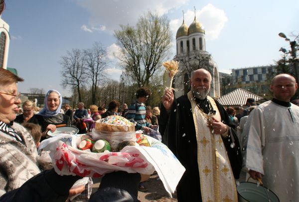A priest splashes holy water onto Easter cakes - Sputnik International