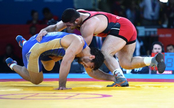 Russia's Abdusalam Gadisov (in blue) wrestles Iran's Reza Yazdani at the 2012 Olympic Games in London. - Sputnik International