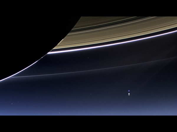 An image by NASA's Cassini spacecraft shows Saturn and its rings, and Earth and its moon (arrow) in the same frame. - Sputnik International