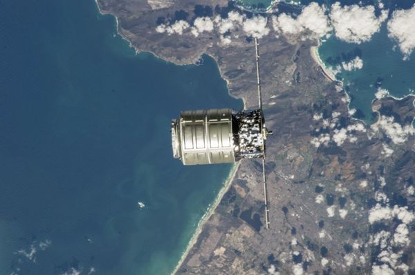 The International Space Station’s robotic arm extends toward the Cygnus spacecraft just prior to docking maneuvers on Sept. 29, 2013. - Sputnik International