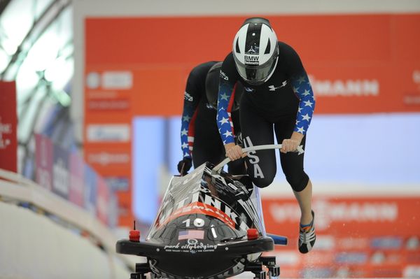 Sochi hopeful Jamie Greubel, foreground, pushing the USA-2 bobsled embossed with the logo of the Russian vodka brand Putinka at the World Cup in Calgary, Canada, last weekend together with Katie Eberling. - Sputnik International