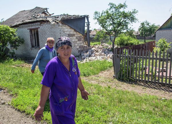 Semyonovka villagers near a house destroyed by artillery and airstrikes (Achive) - Sputnik International