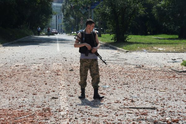A militia soldier near a residential building in the center of Donetsk, hit by the shelling of the Ukrainian Army. - Sputnik International