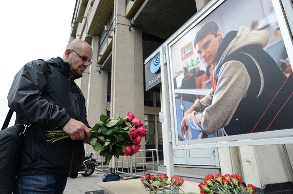 A colleague lays flowers in memory of the Russian journalist Andrei Stenin, who was killed in Ukraine. - Sputnik International