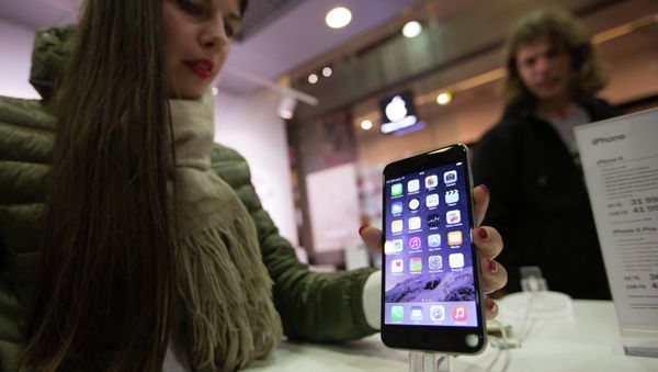 A woman taking a look at the new iPhone in one of Russia's official iPhone resellers; it may now be cheaper to buy a contract-free iDevice in Russia than elsewhere. - Sputnik International